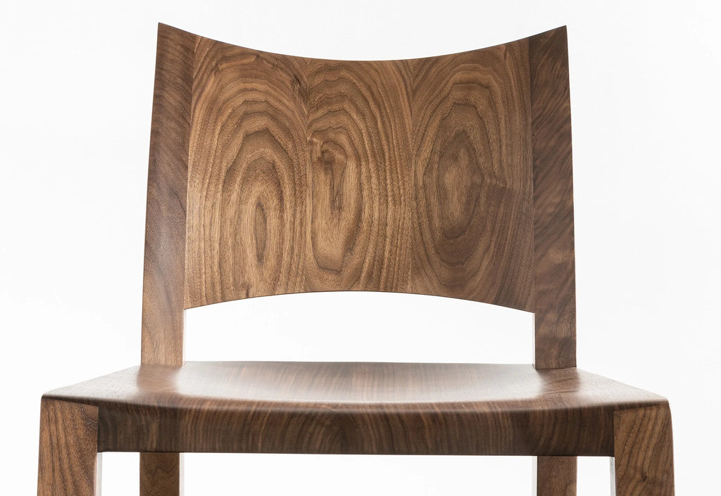 Chaise - Outre son profil simple et saisissant, la caractéristique la plus marquante de la Chaise est son dossier incurvé en bois dur - une
