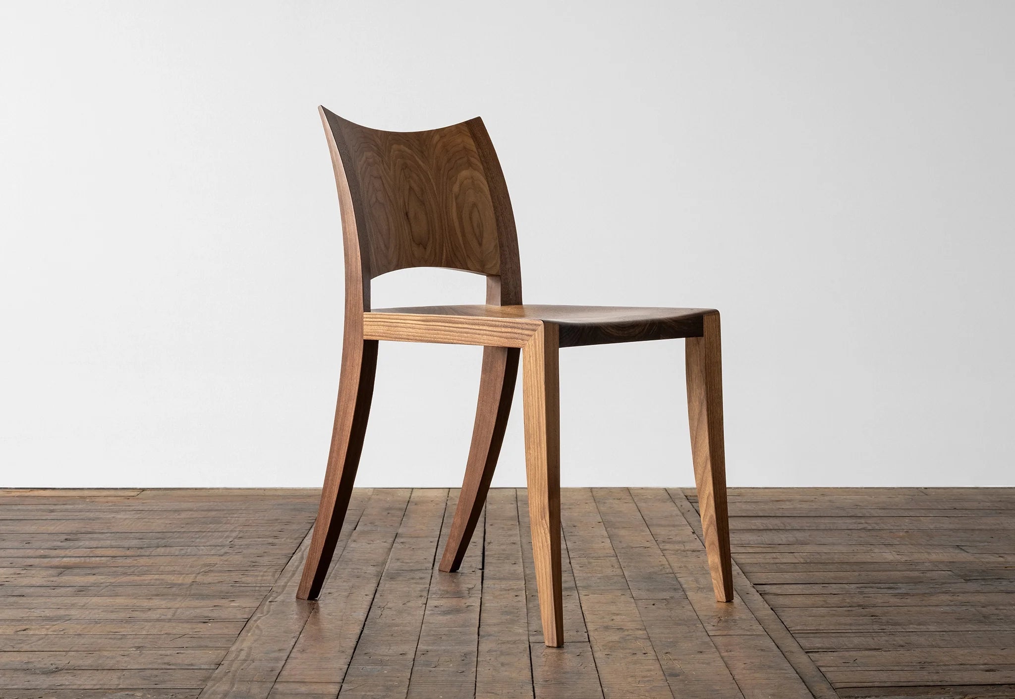 Chaise - Outre son profil simple et saisissant, la caractéristique la plus marquante de la Chaise est son dossier incurvé en bois dur - une